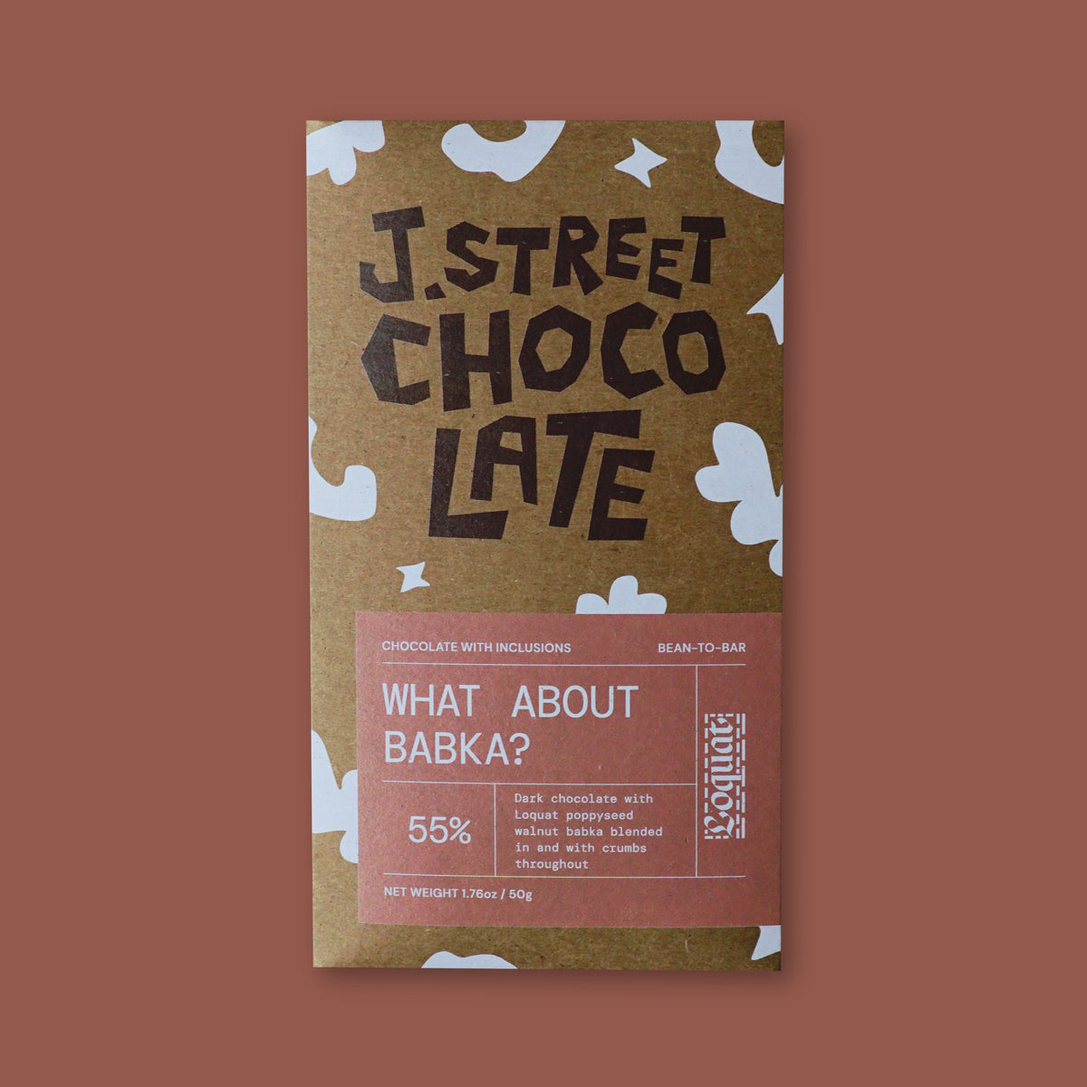 A chocolate bar package labeled 'J. Street Choco Late' on a solid dusty rose background.